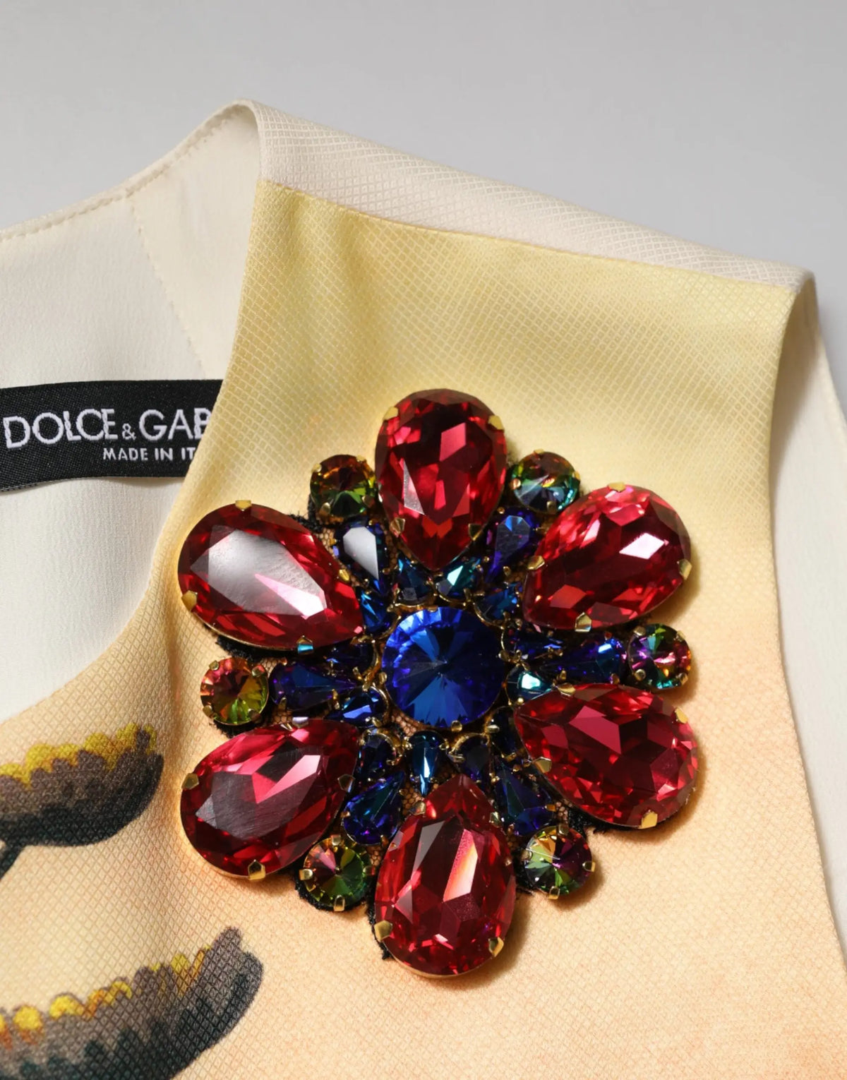 Broche en cristal multicolore vibrant avec pierres rouge et bleu en forme de larme sur robe mini droite dolce & gabbana