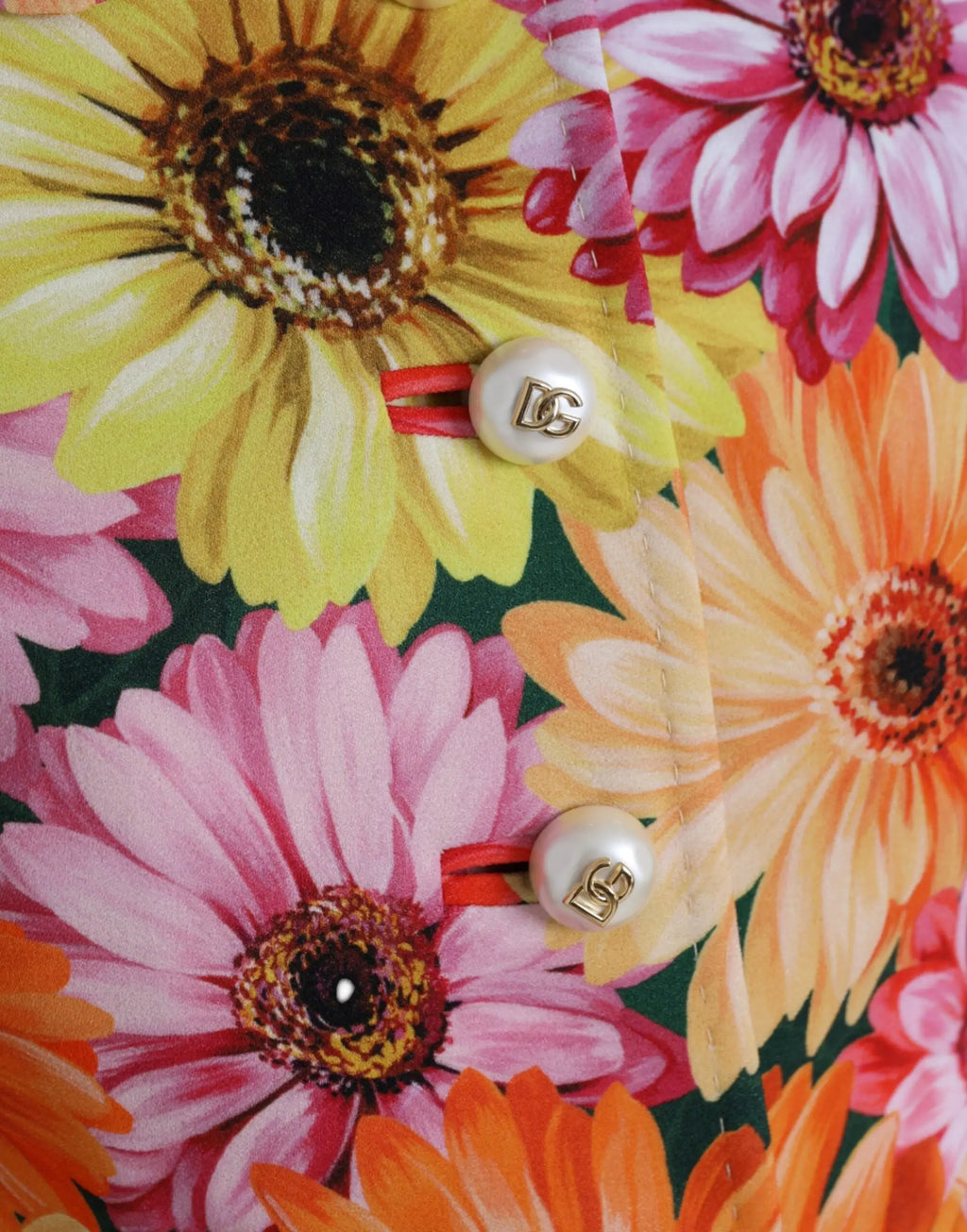 Boutons nacrés avec logo dg doré sur veste dolce gabbana multicolore imprimé marguerites sur tissu vert foncé