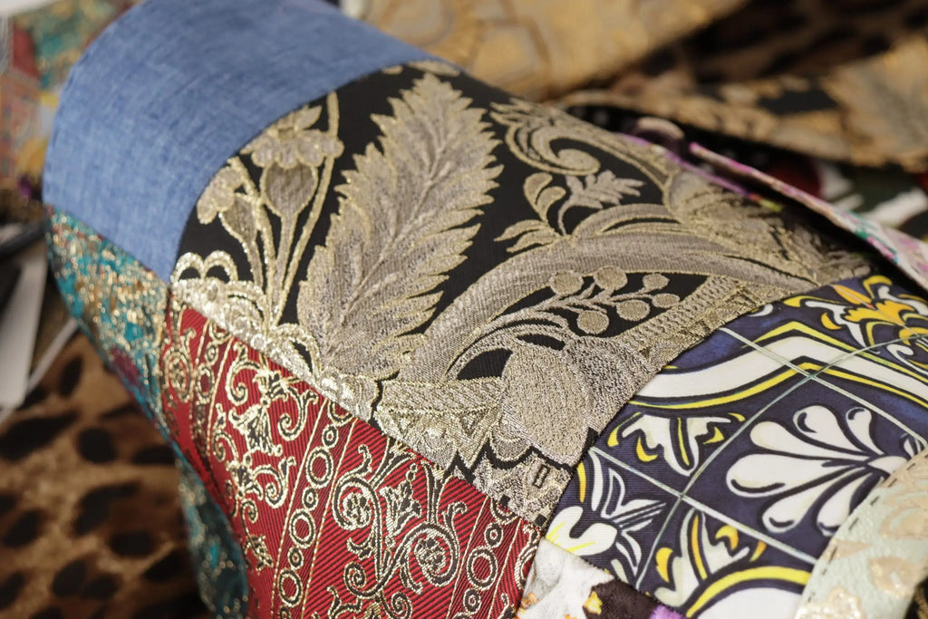 Sac cylindrique patchwork dolce & gabbana en brocart noir et or, soie rouge, denim bleu et imprimés multicolores