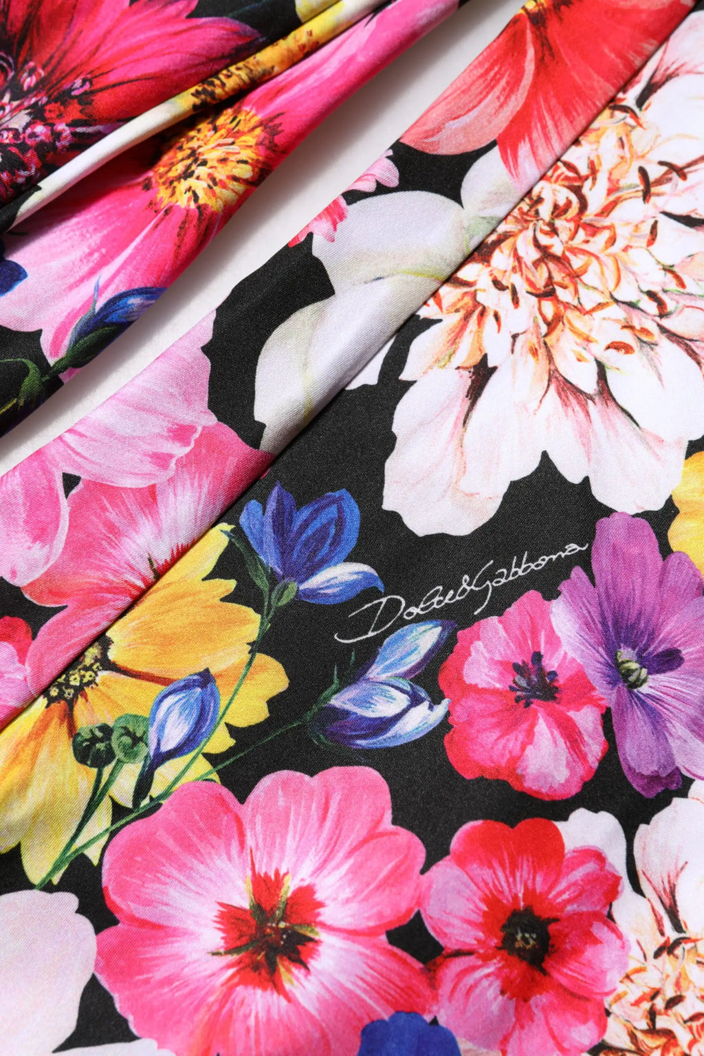 Écharpe en soie vibrante dolce & gabbana avec fleurs rose blanc bleu jaune sur fond noir et logo brodé en argent