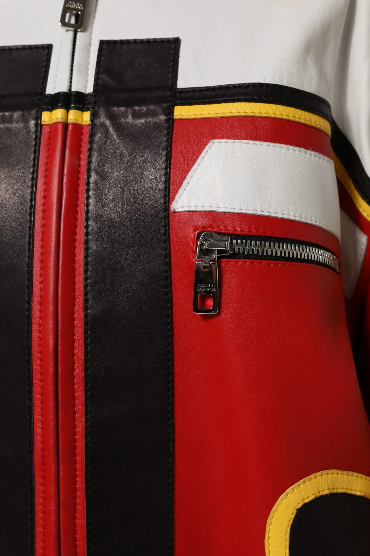 Veste moto multicolore en cuir rouge et noir avec accents blancs et jaunes et fermeture éclair argentée dolce gabbana