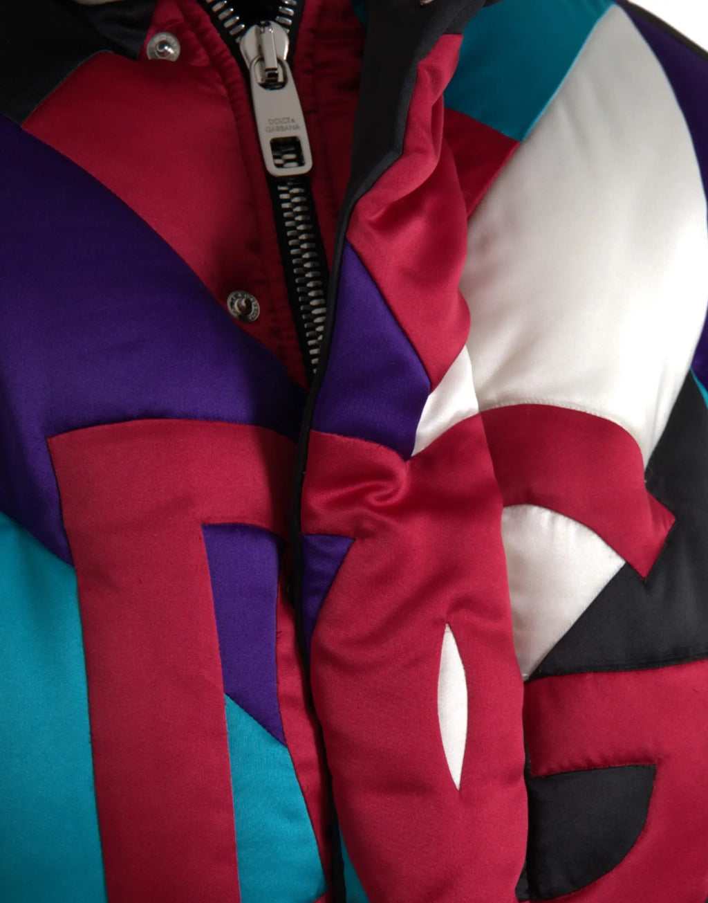 Veste matelassée dolce & gabbana multicolore avec panneaux géométriques rouges, violets, teal, blancs, noirs et fermeture argentée