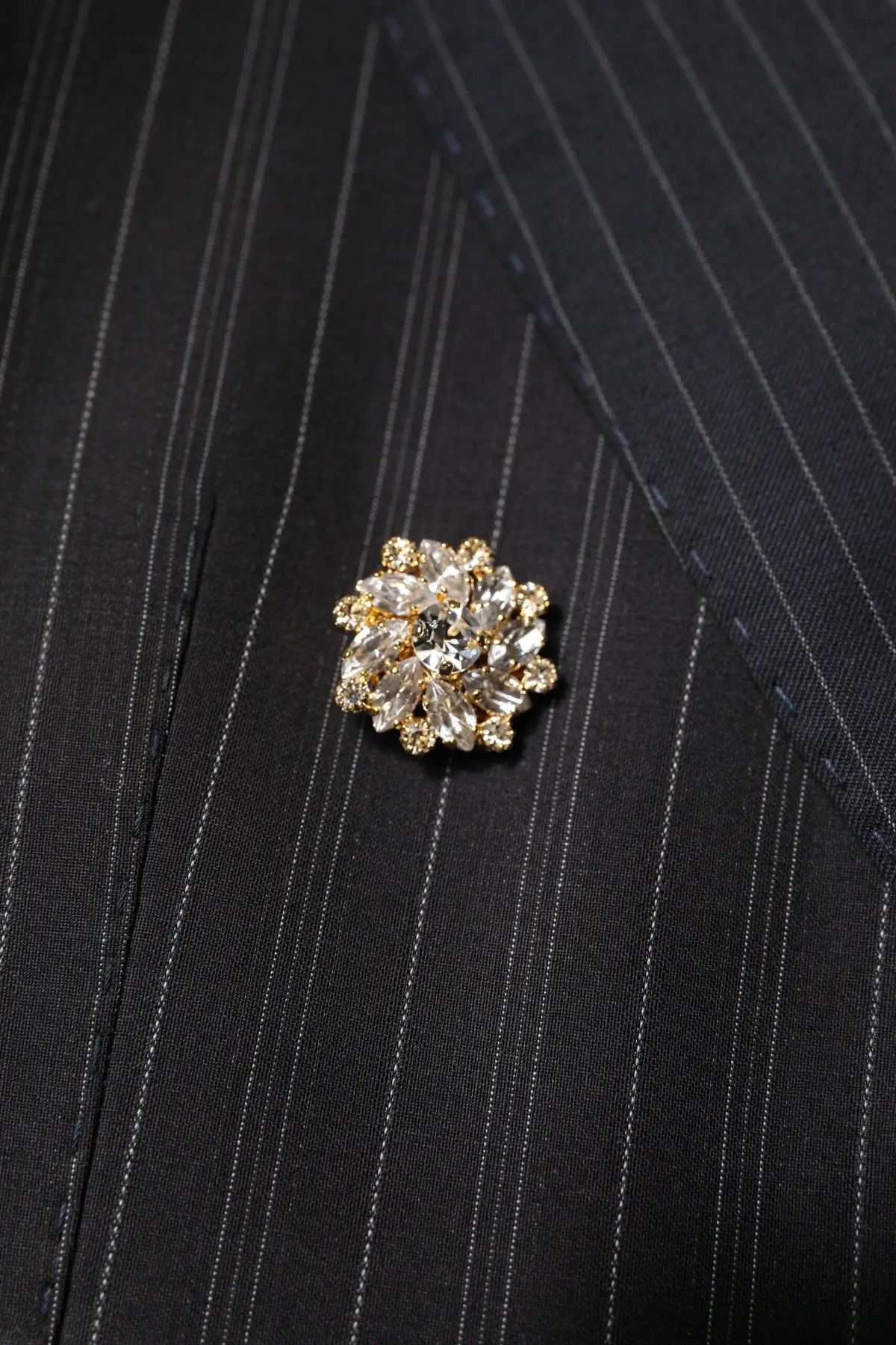 Broche étincelante dorée avec cristaux clairs facettés en motif floral sur veste patchwork multicolore dolce gabbana
