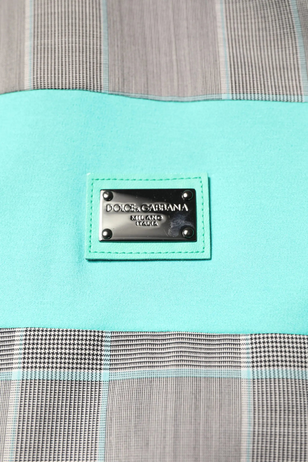 Patch en cuir turquoise dolce gabbana milano italy avec lettrage métallique argenté sur veste coupe-vent multicolore à carreaux