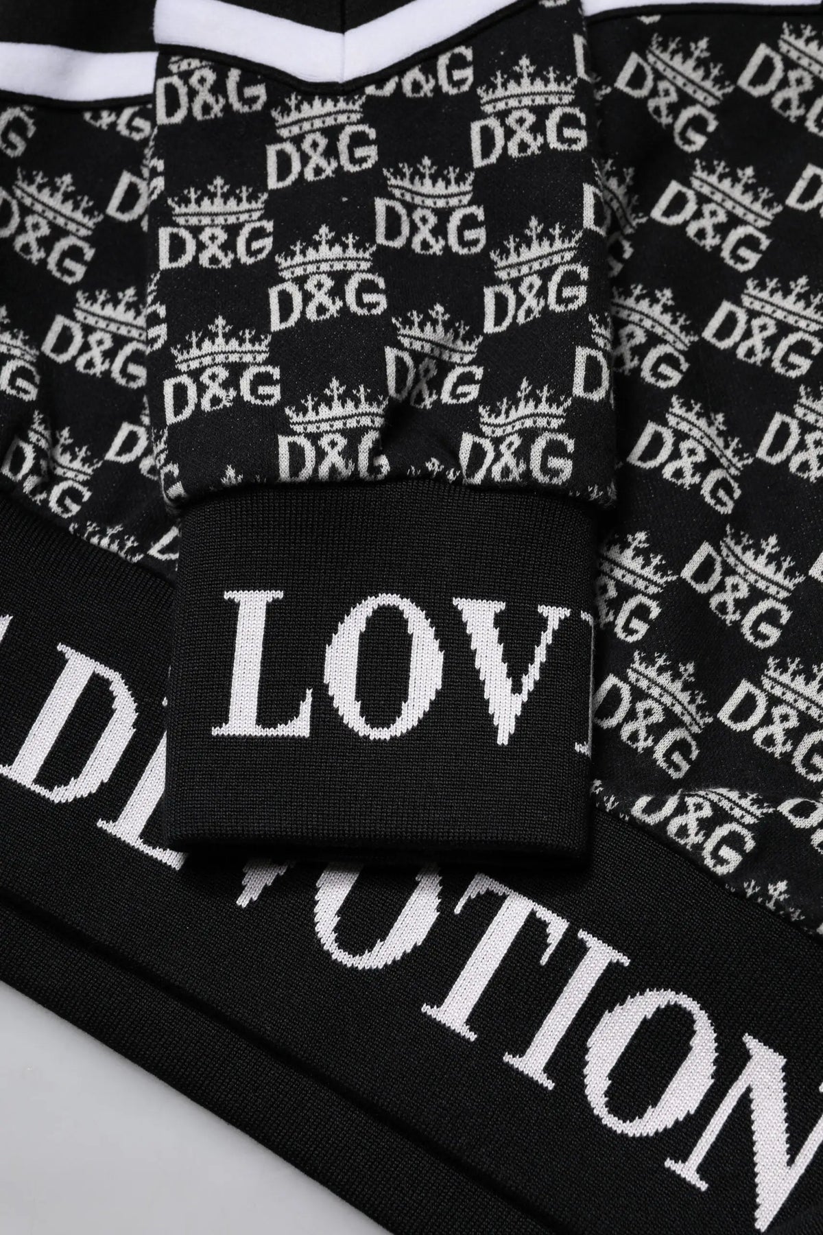 Sweatshirt dolce & gabbana noir en tricot avec logo d&g blanc répété couronnes et love en lettres blanches sur bord côte