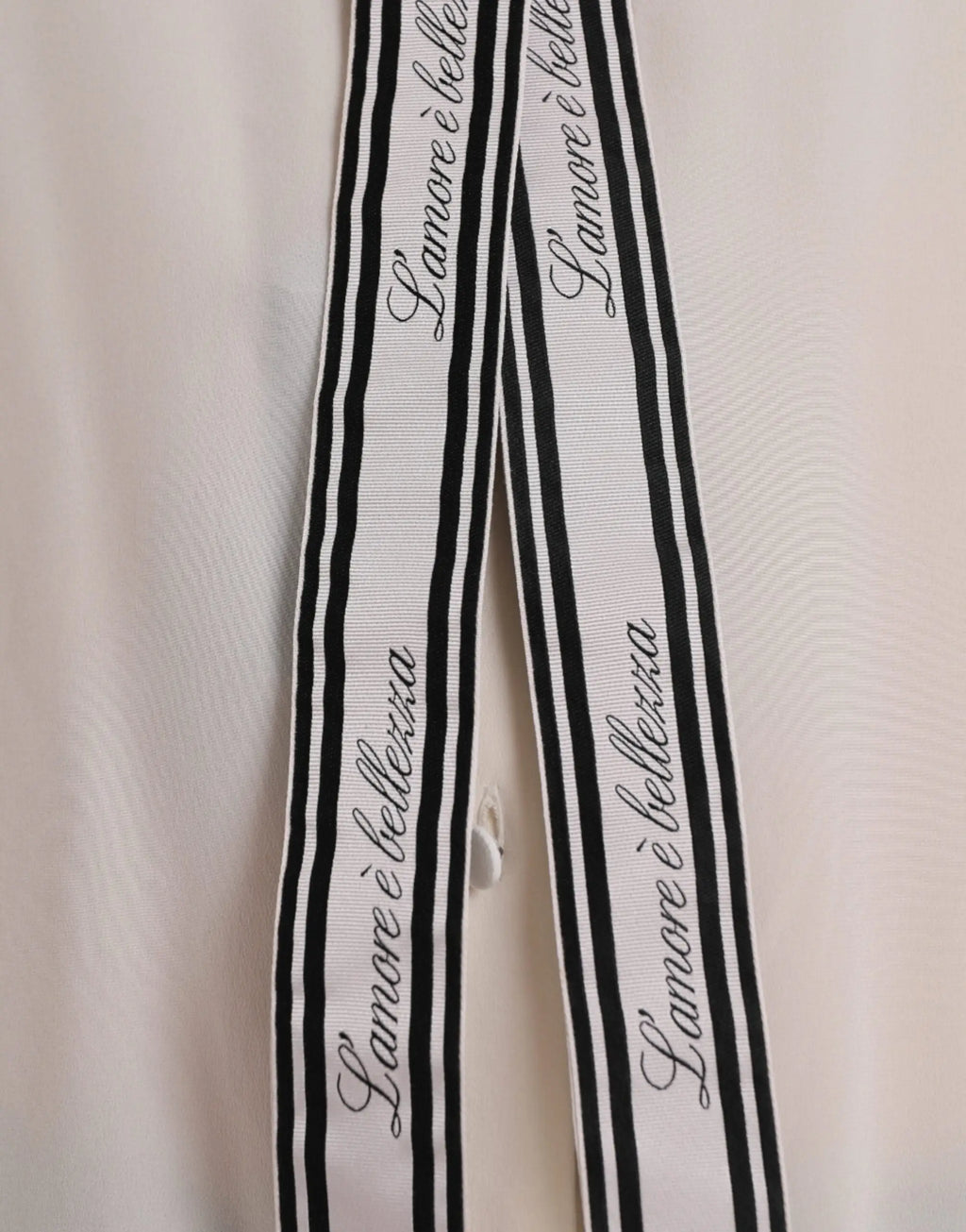 Longue blouse boutonnée dolce & gabbana écrue avec ruban rayé noir et blanc et texte en cursive l amoure è belletta