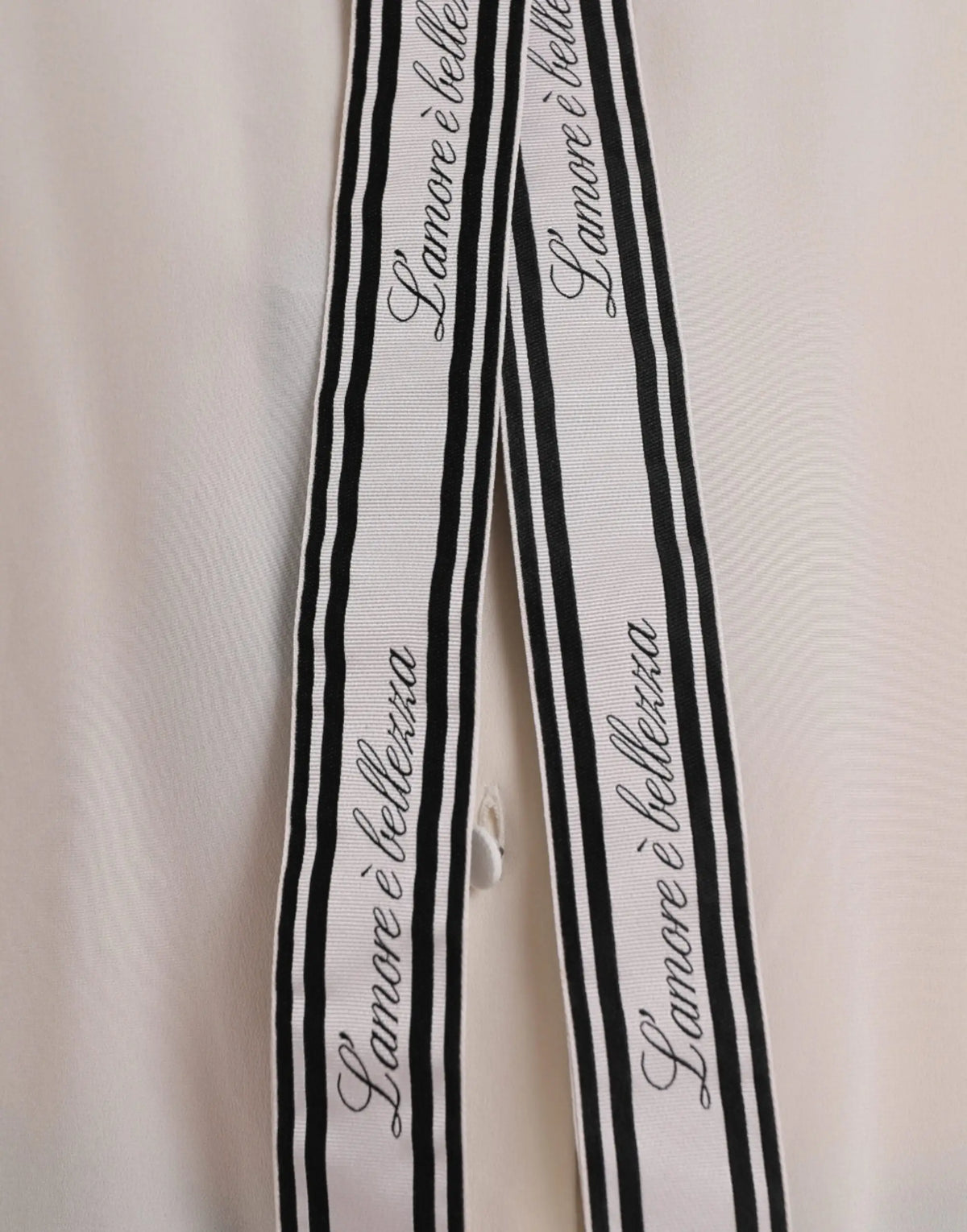 Longue blouse boutonnée dolce & gabbana écrue avec ruban rayé noir et blanc et texte en cursive l amoure è belletta