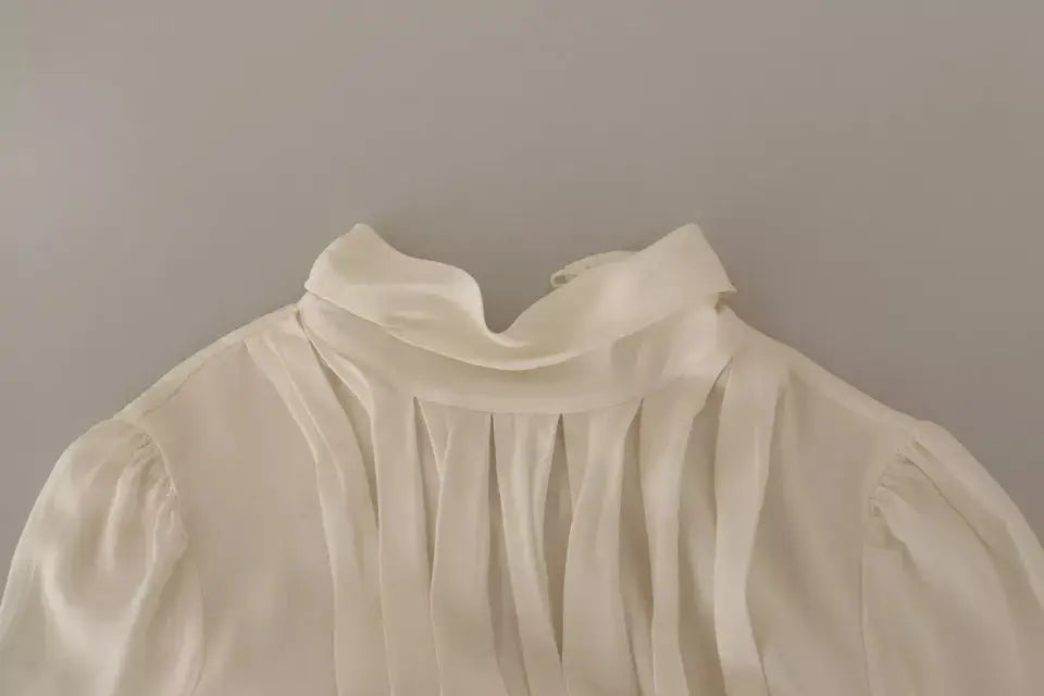 Blouse douce ivoire dolce & gabbana en soie avec col roulé à manches longues et col haut volanté plissé devant