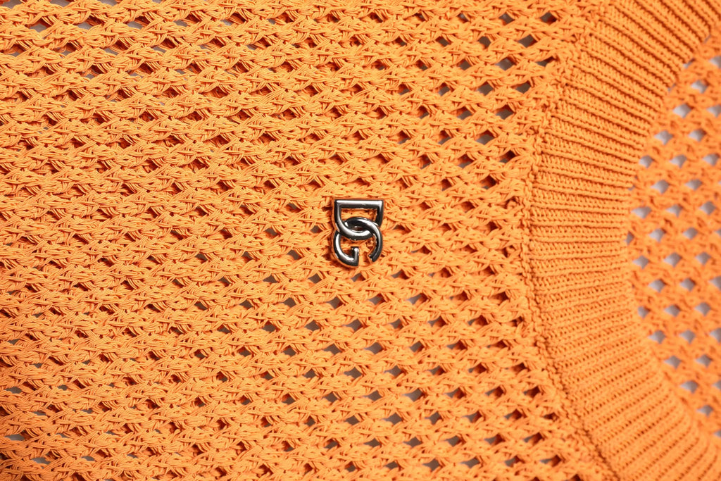 Logo argenté métallique entrelacé sur tissu orange vif en tricot du t shirt sans manches en cachemire dolce gabbana