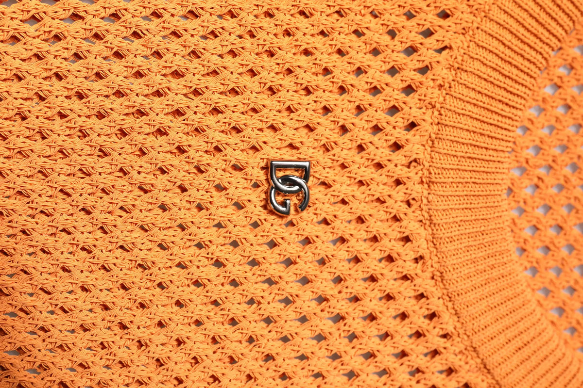 Logo argenté métallique entrelacé sur tissu orange vif en tricot du t shirt sans manches en cachemire dolce gabbana