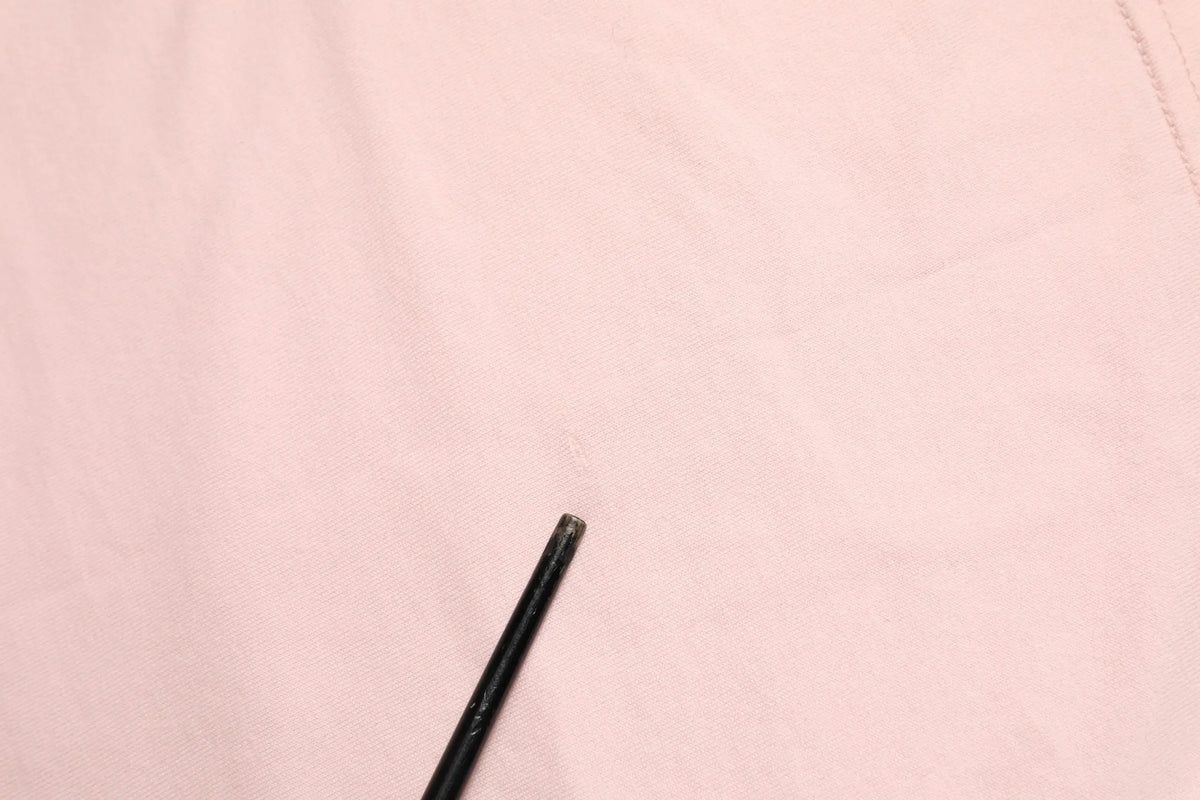 Crayon noir reposant sur tissu rose pâle du t-shirt en coton dolce gabbana dg 84 motif sacré cœur