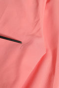 Un crayon noir repose sur un tissu côtelé rose corail doux à côté d un pantalon cigarette taille haute rose dolce & gabbana