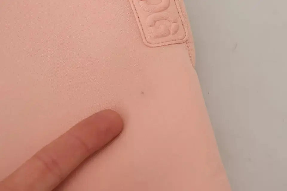 Sleeve pour ordinateur portable chanel rose en simili cuir avec logo embossé accompagne un pantalon jogger dolce & gabbana rose en polyester
