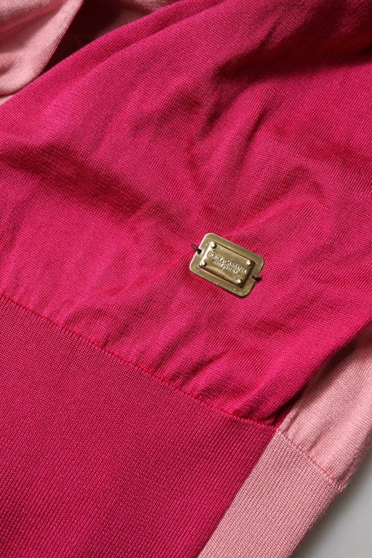 Plaque métallique rectangulaire dorée embossée dolce & gabbana sur tissu tricot fuchsia à col ascot et manches courtes roses