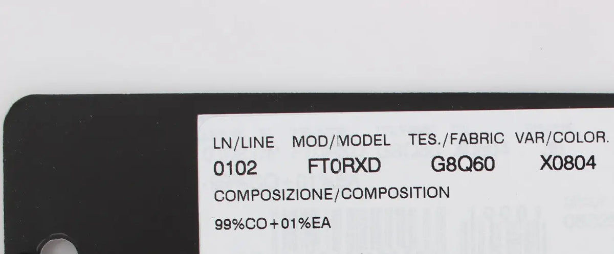 Étiquette noire avec texte blanc indiquant les détails du modèle des jeans slim capris à pois de Dolce & Gabbana