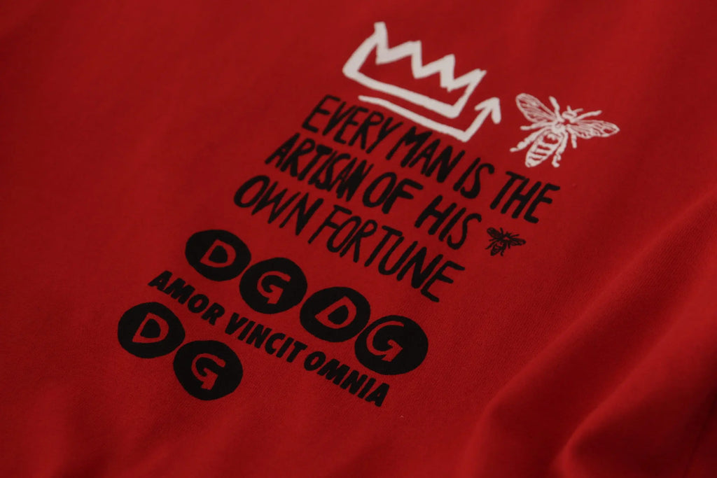 T-shirt dolce & gabbana rouge avec graphique couronne et abeille blanche et texte noir artisan de sa propre fortune