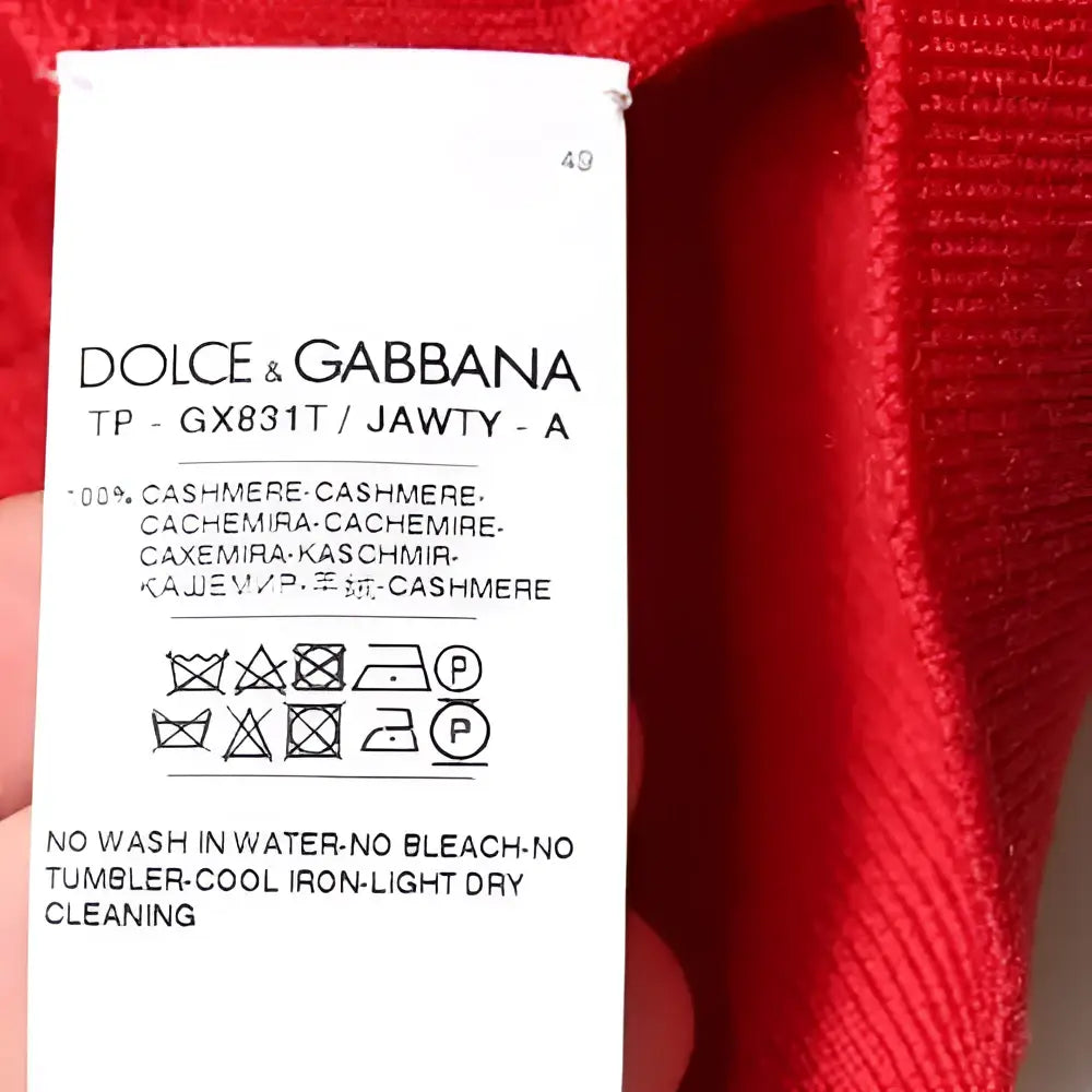 Étiquette rouge dolce & gabbana en cachemire avec instructions d’entretien multilingues au dos d’un pull col roulé