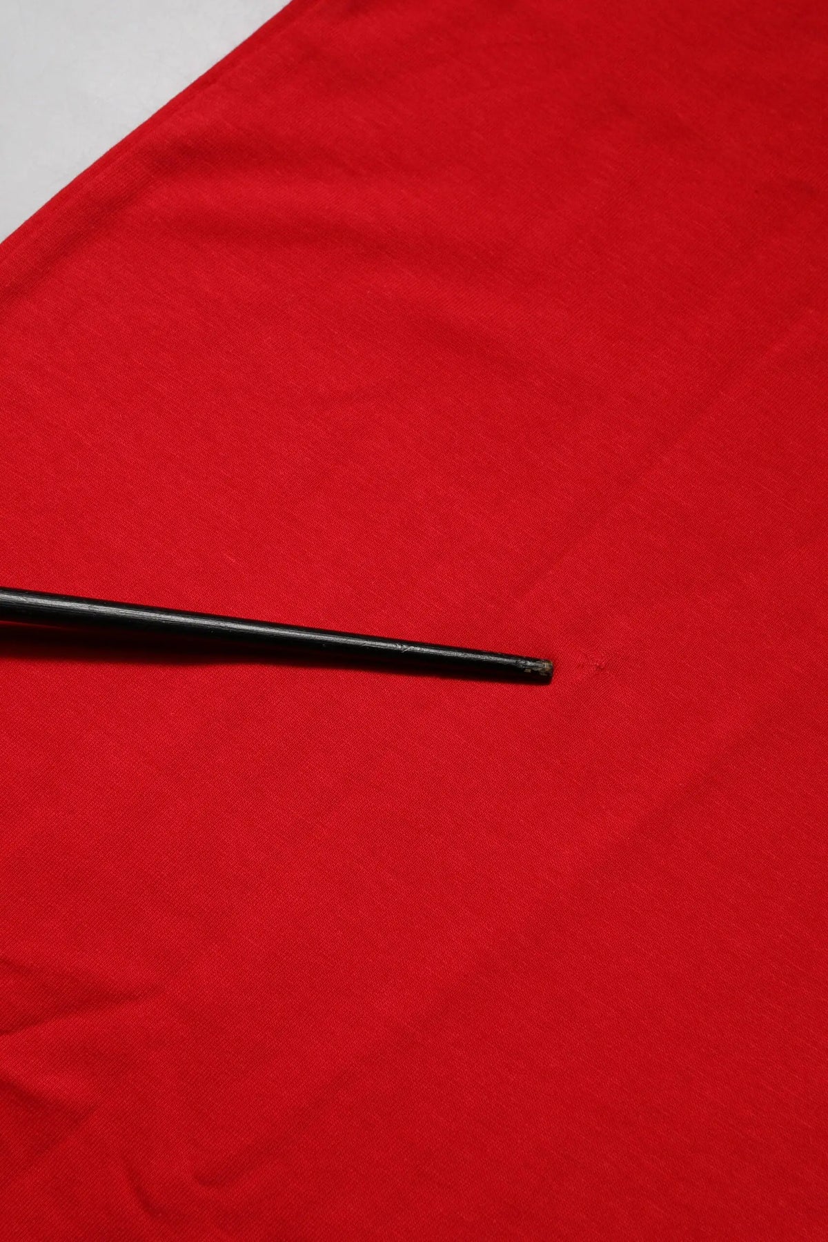 Chopsticks noirs en bois reposant sur un tissu rouge vibrant avec un t shirt rouge en coton manches courtes dolce gabbana