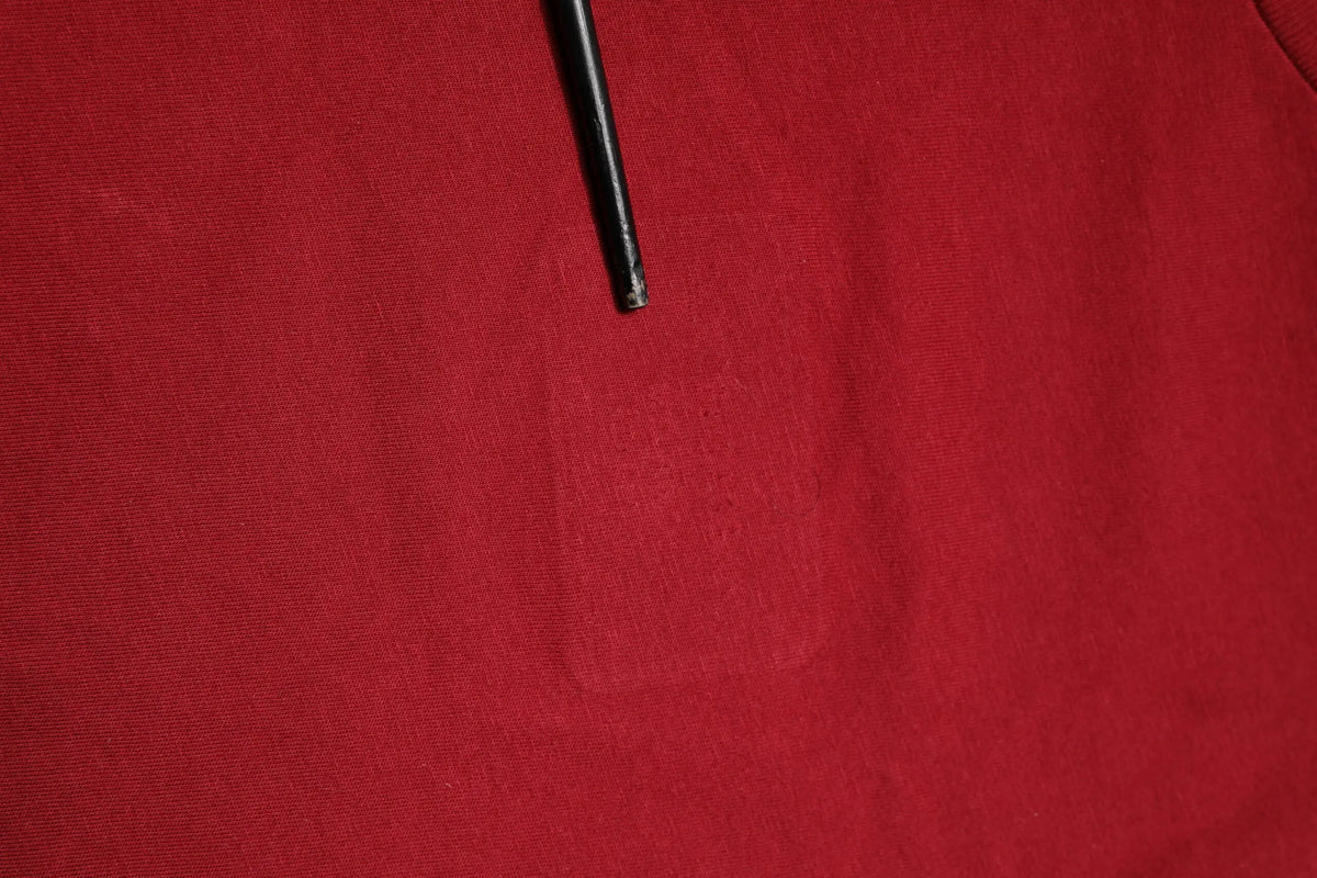 Stylo noir cylindrique posé sur tissu rouge à côté d un t shirt coton rouge dolce & gabbana manches courtes col rond