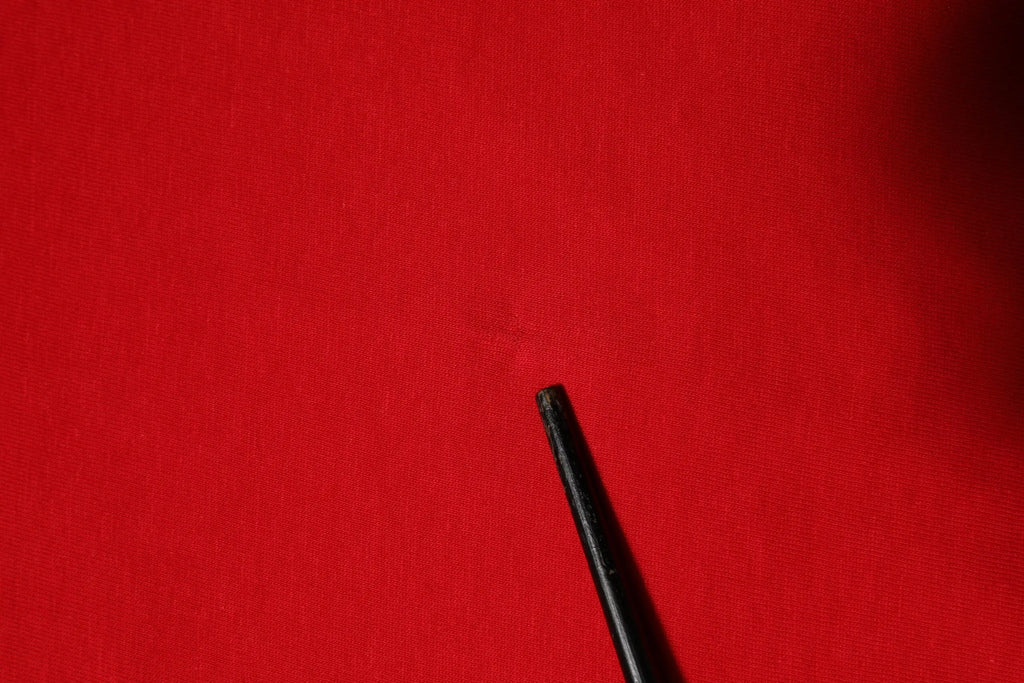 Stylo noir sur fond rouge vif avec t-shirt dolce & gabbana rouge en coton manches courtes col rond