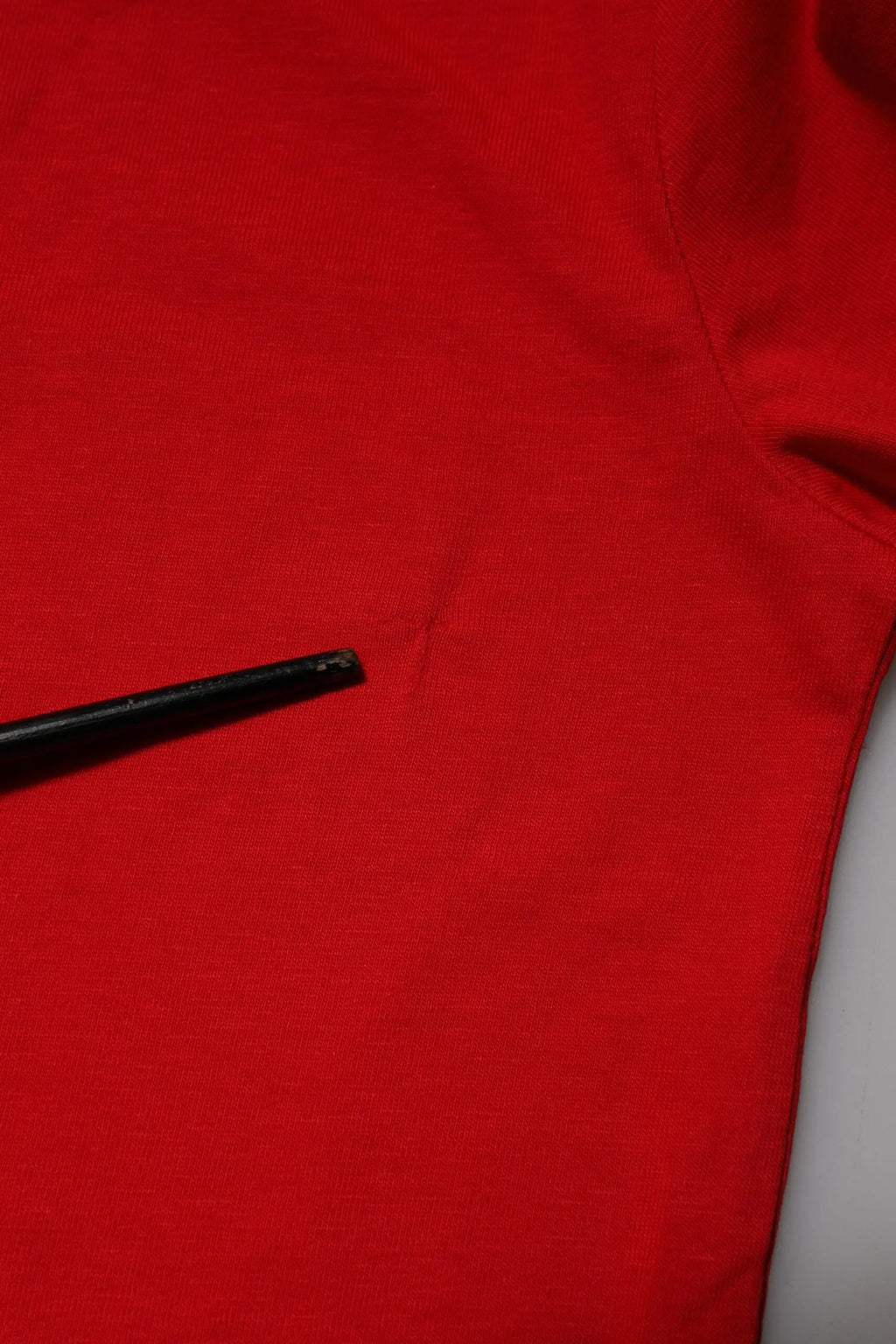 Un stylo noir posé sur un tissu rouge vif du t-shirt dolce & gabbana en coton manches courtes col rond