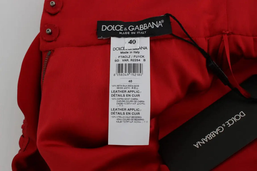 Pantalon rouge dolce & gabbana en soie avec appliqués en cuir et boutons argentés fabriqué en italie