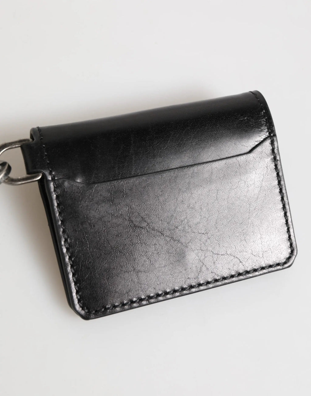 Portefeuille dolce & gabbana en cuir noir avec texture craquelée, coutures précises et porte-clés métallique