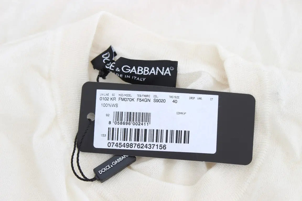Étiquette dolce & gabbana noire avec étiquette blanche et code-barres sur tissu crème d un pull 100 pour cent cachemire blanc