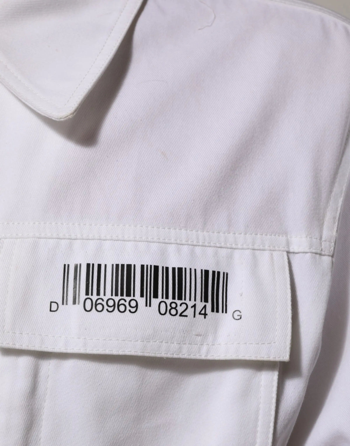 Chemise blanche en coton dolce gabbana avec étiquette code-barres cousue sur la poche poitrine
