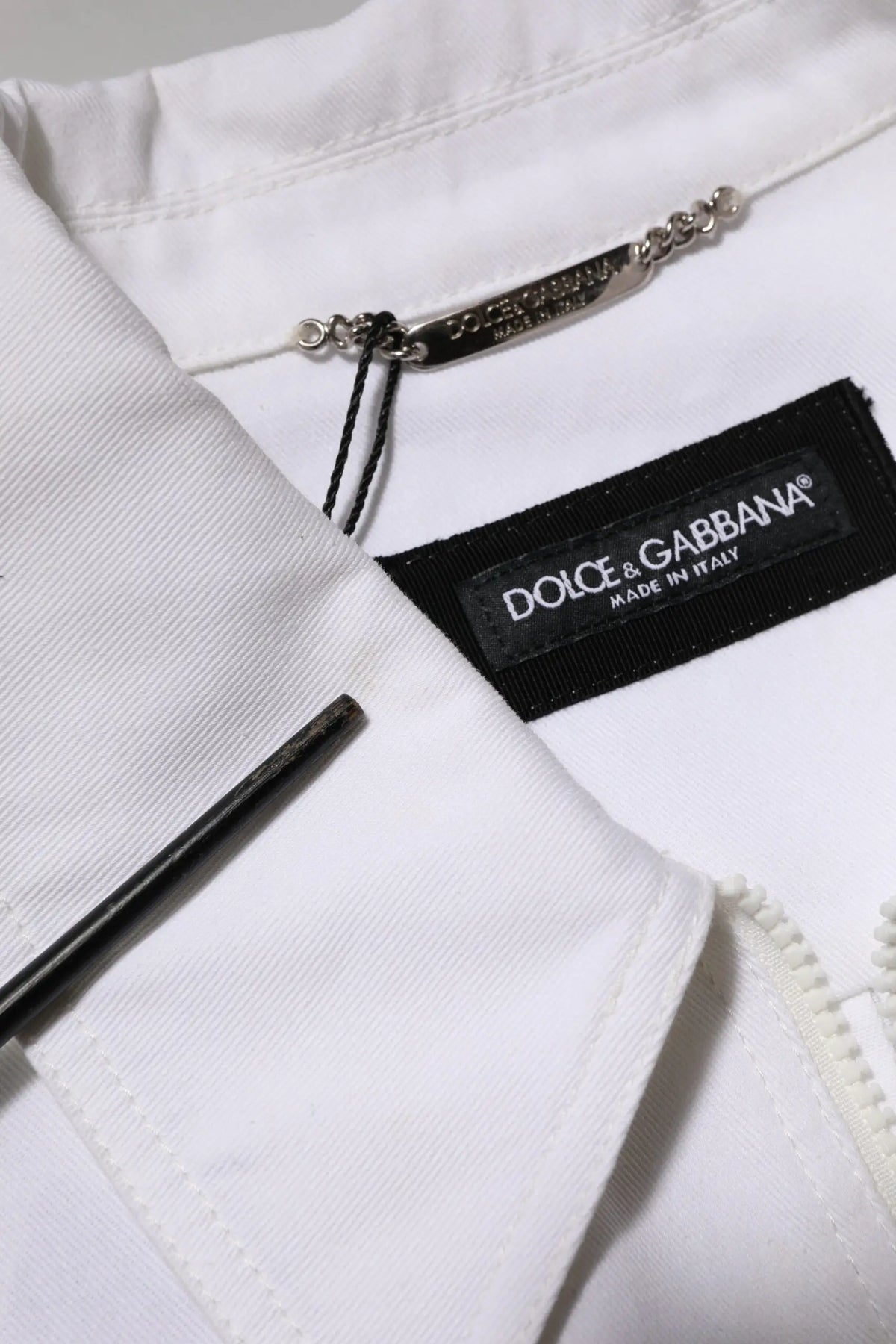Veste blanche dolce & gabbana avec étiquette noire et tirette argentée dans la combinaison pantalon utility zip barcode