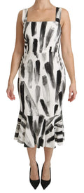 Une femme porte une robe midi dolce & gabbana en viscose blanche et noire avec motifs pinceaux et décolleté carré