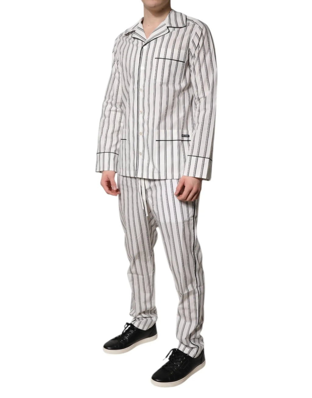 Un homme porte un ensemble de pyjama homme en coton blanc et noir à rayures verticales dolce & gabbana avec chemise boutonnée et manches longues