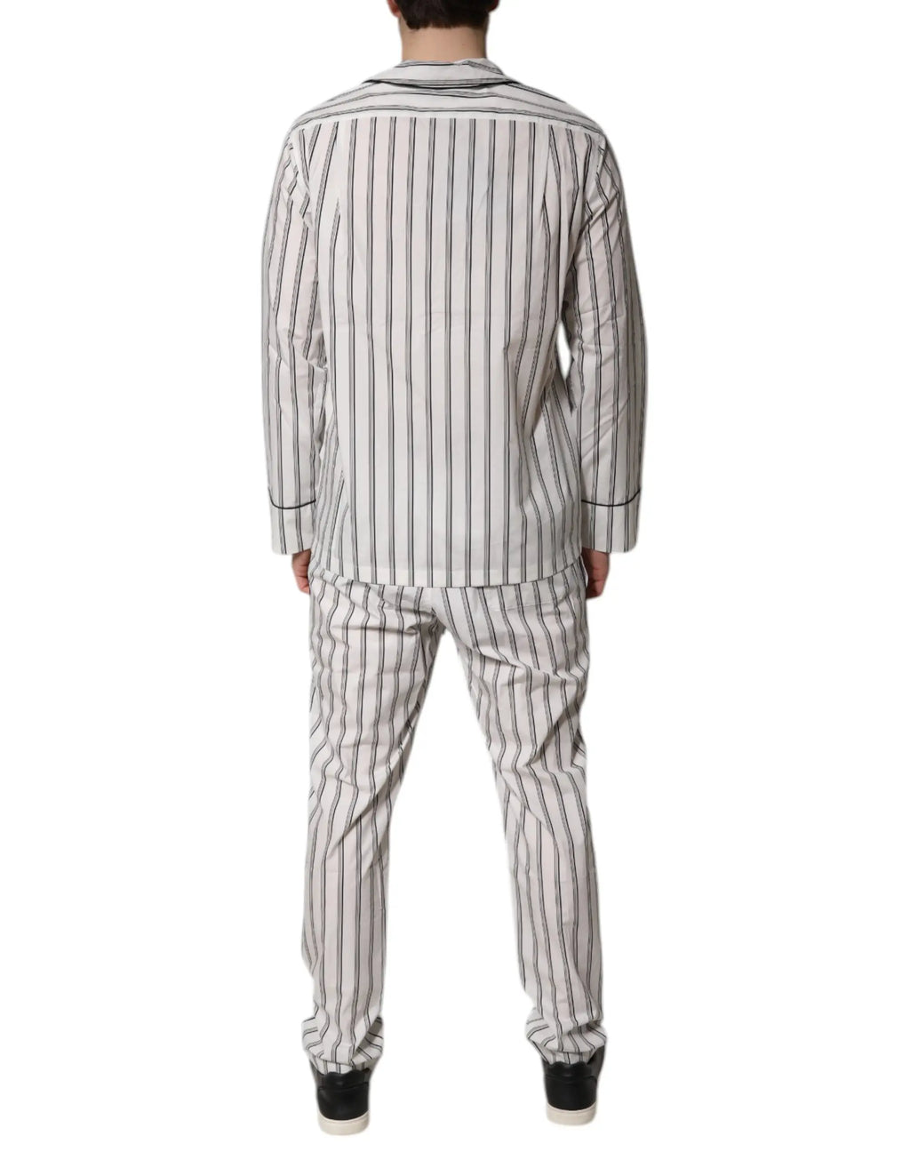 Un homme portant un ensemble de pyjama dolce & gabbana en coton blanc et noir avec rayures verticales pour homme