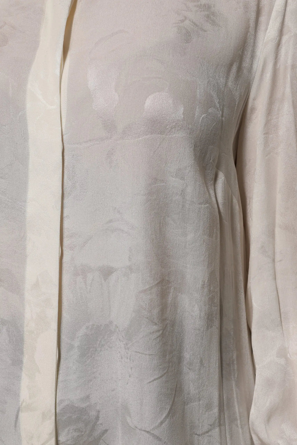 Une blouse dolce & gabbana blanche en soie délicate avec motif floral subtil et manches longues boutonnées