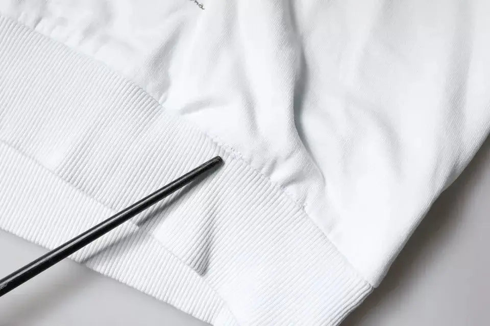 Manchon en maille côtelée blanc avec un bâtonnet noir sur le pull à capuche en coton caesar de dolce & gabbana