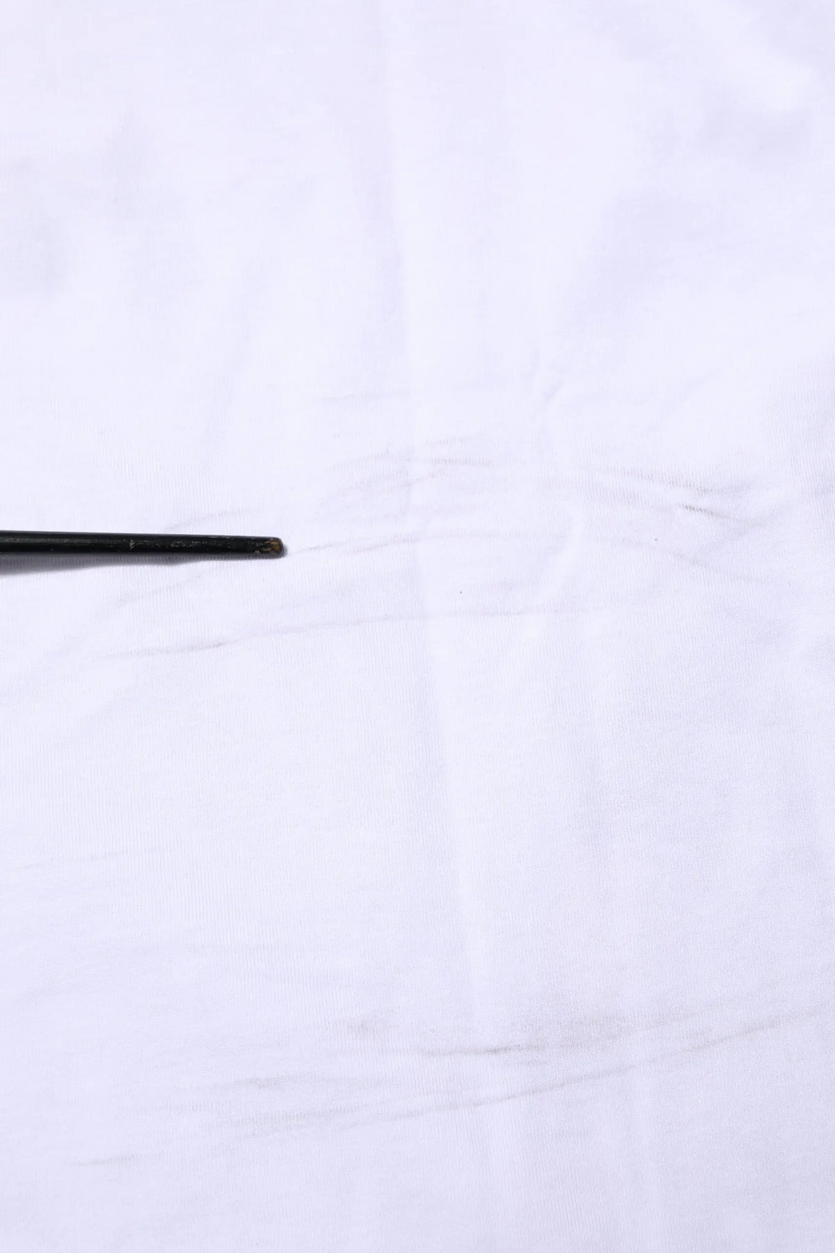 Chopsticks noirs avec surface légèrement texturée à côté d’un t-shirt dolce & gabbana camouflage blanc en coton pour homme