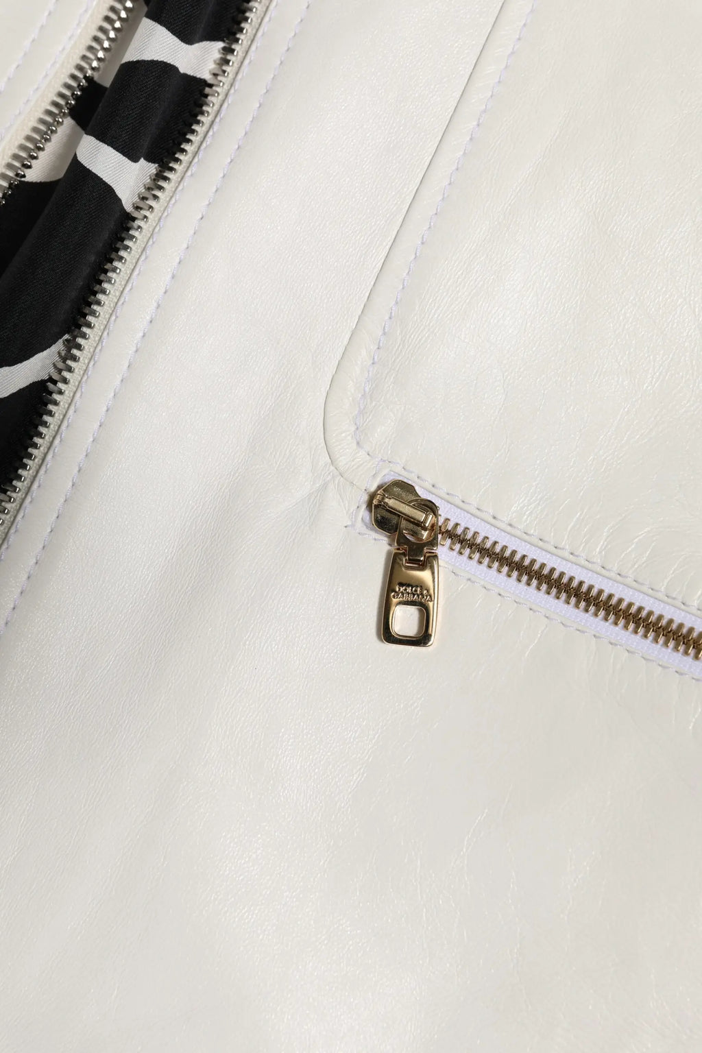 Pochette blanche en cuir avec fermeture éclair dorée et doublure intérieure rayée noir et blanc pour veste dolce & gabbana
