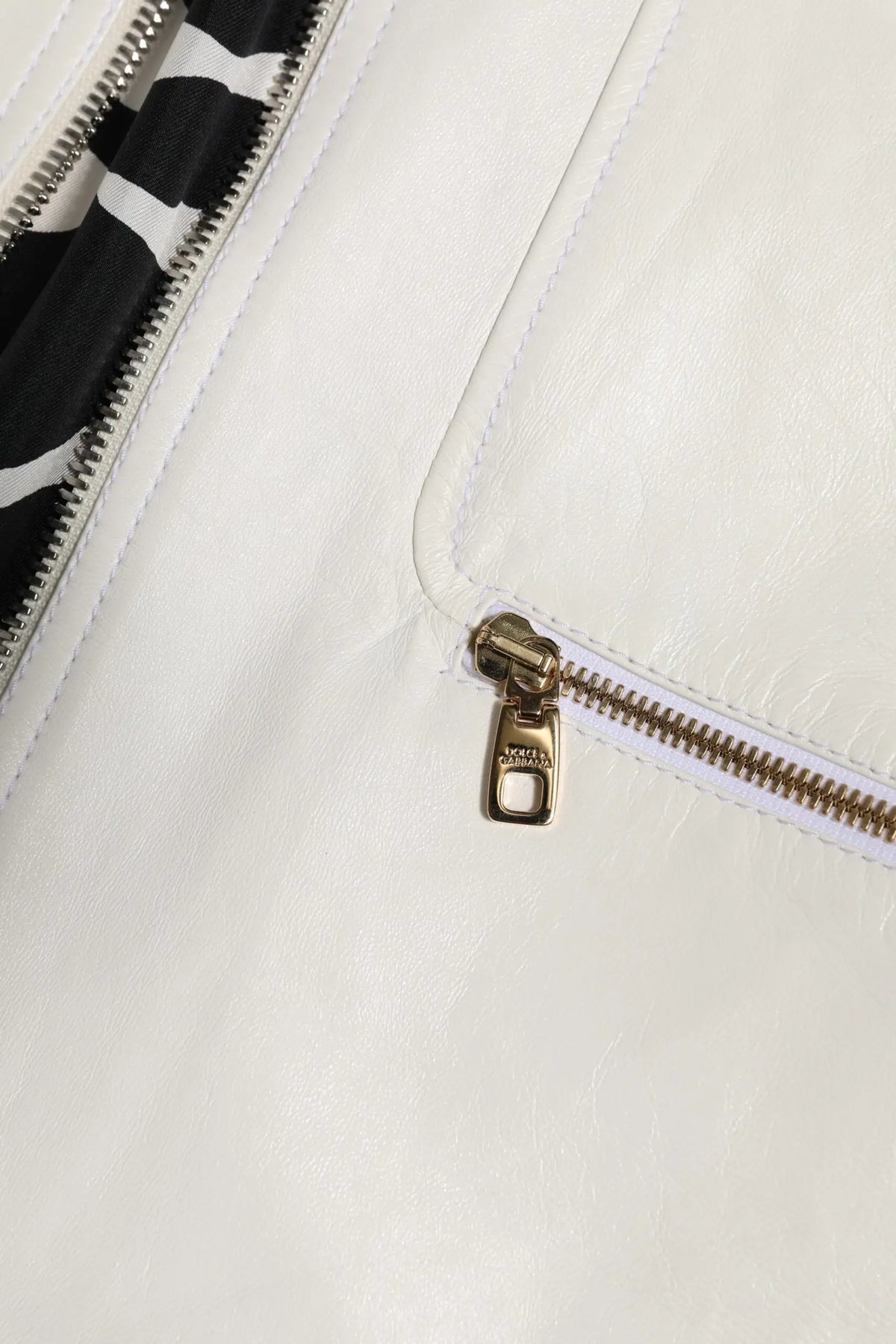 Pochette blanche en cuir avec fermeture éclair dorée et doublure intérieure rayée noir et blanc pour veste dolce & gabbana