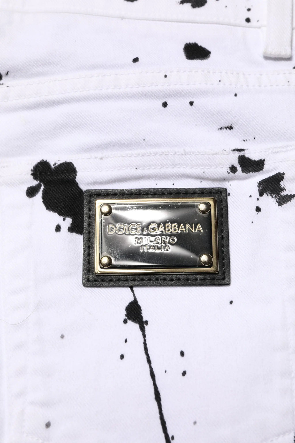 Jeans skinny en denim blanc dolce & gabbana avec motif éclaboussures noires et plaque métallique milano italia