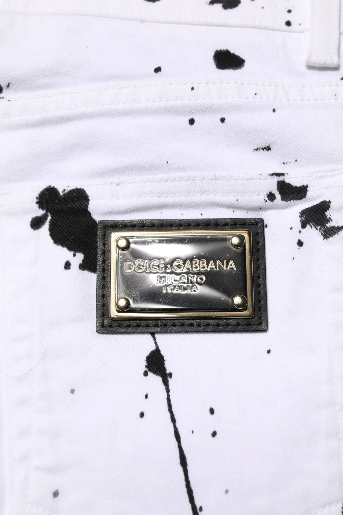 Jeans skinny en denim blanc dolce & gabbana avec motif éclaboussures noires et plaque métallique milano italia