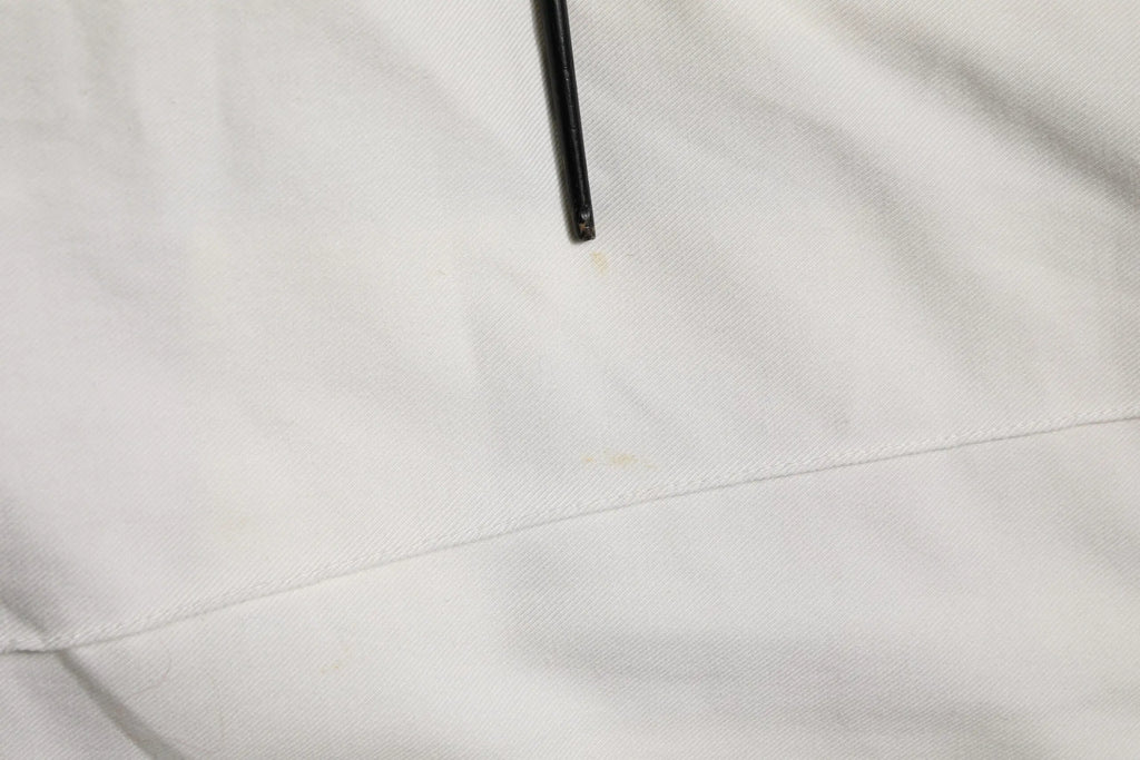 Un stylo noir posé sur un tissu blanc des pantalons jogger cargo en coton blanc pour homme dolce & gabbana