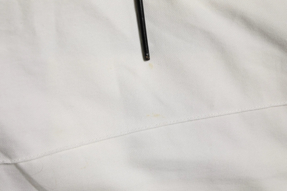 Un stylo noir posé sur un tissu blanc des pantalons jogger cargo en coton blanc pour homme dolce & gabbana