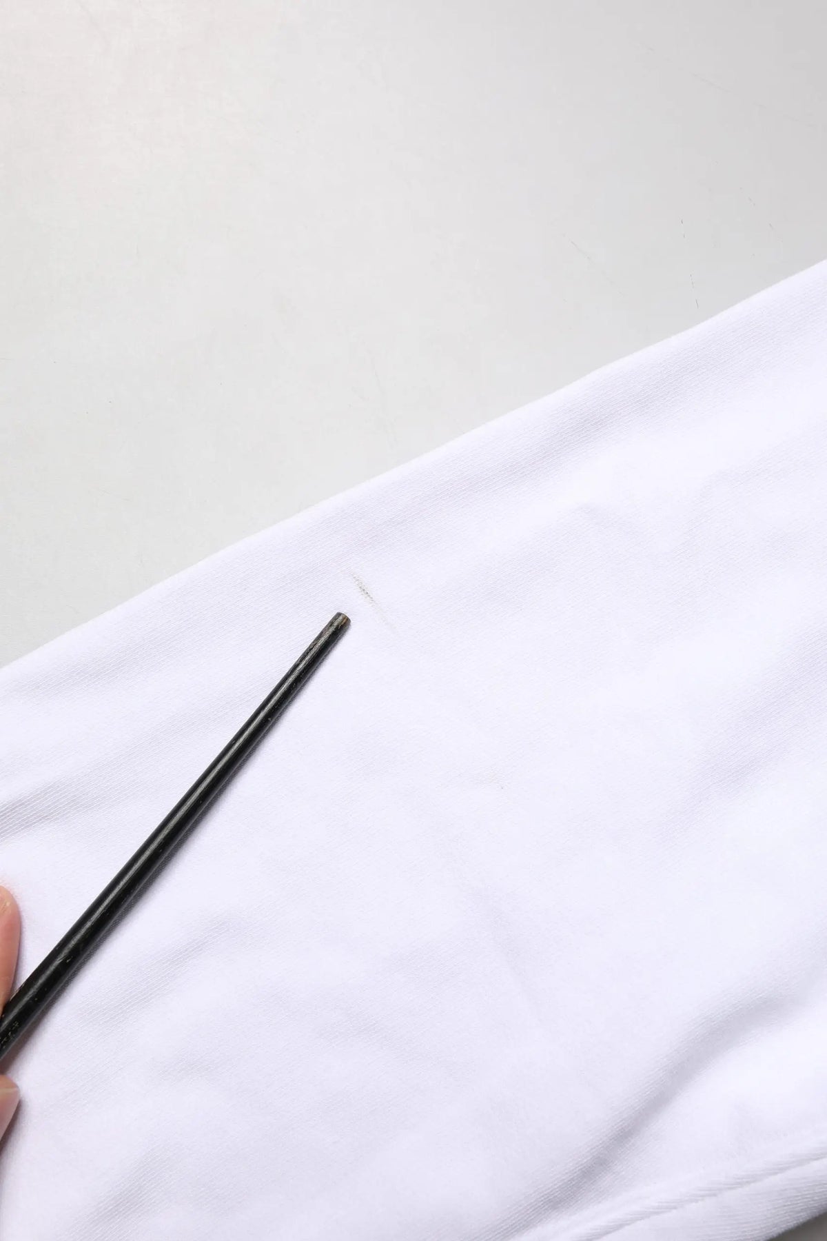 Chopsticks noirs posés sur tissu blanc à côté dun sweat blanc en coton dolce gabbana col rond