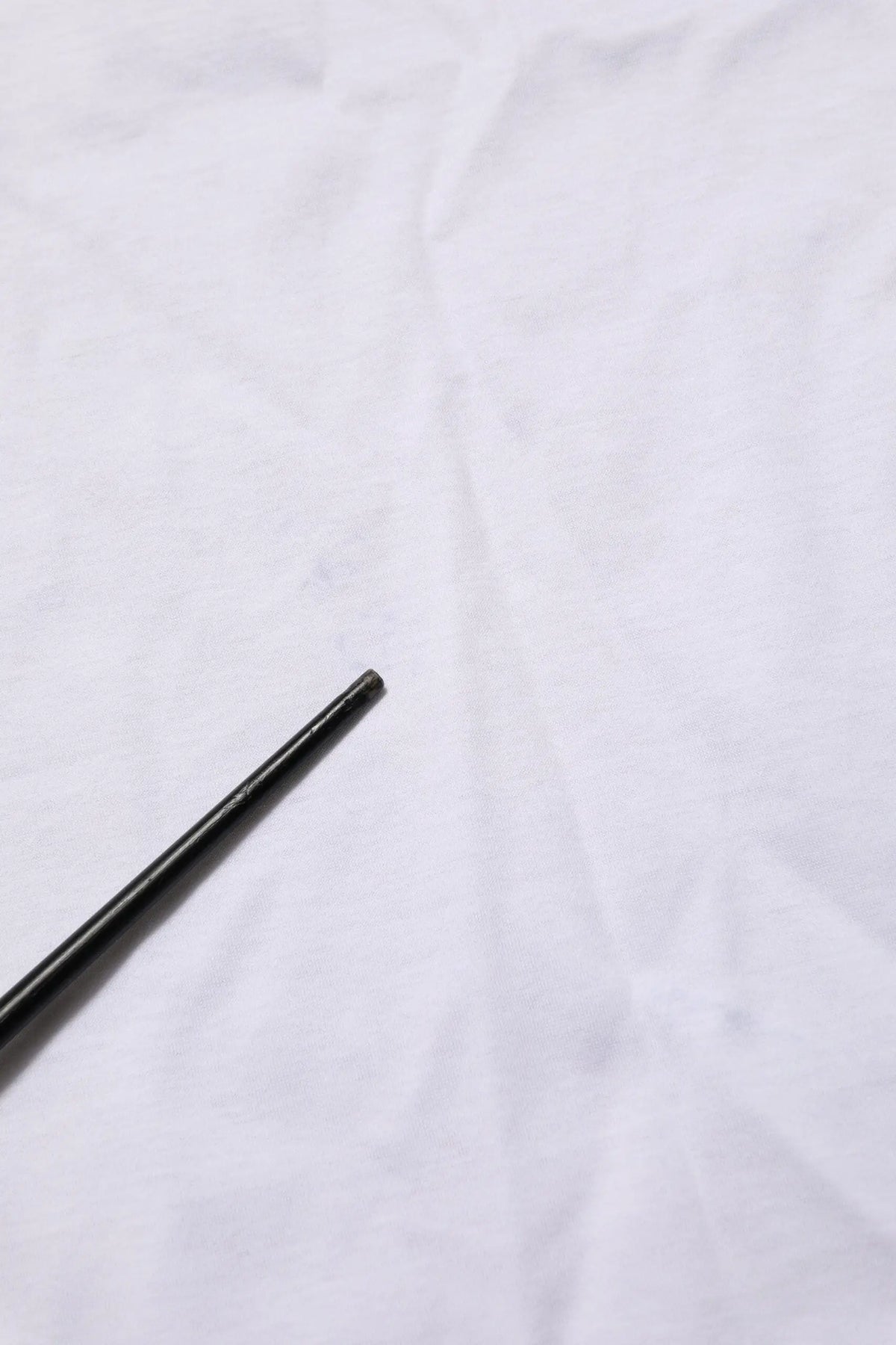 Dolce & gabbana tee-shirt blanc en coton avec col rond et baguettes cylindriques noires mates en arrière-plan