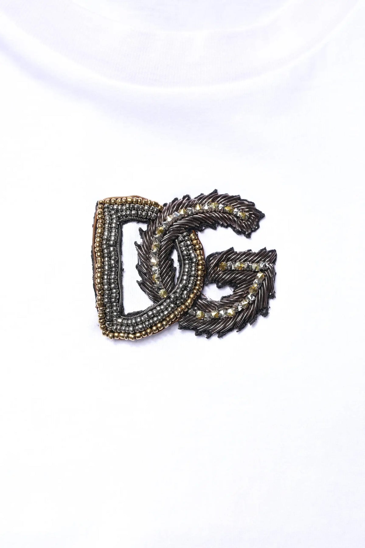 Broche logo dg métallique foncé avec perles fines et petites pierres scintillantes sur t-shirt blanc en coton dolce & gabbana