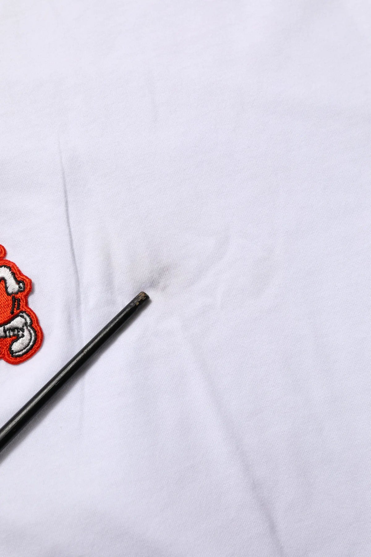 Un t shirt dolce gabbana blanc en coton avec un patch brodé dg love rouge et blanc posé sur tissu blanc