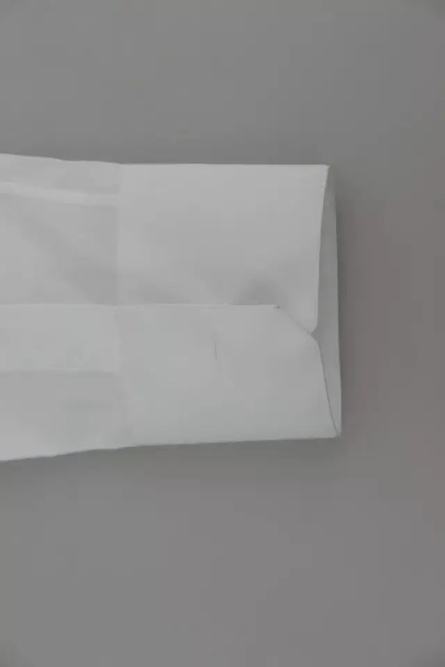Enveloppe blanche en papier avec bords pliés et plis subtils pour chemise formelle en coton blanc gold dolce gabbana