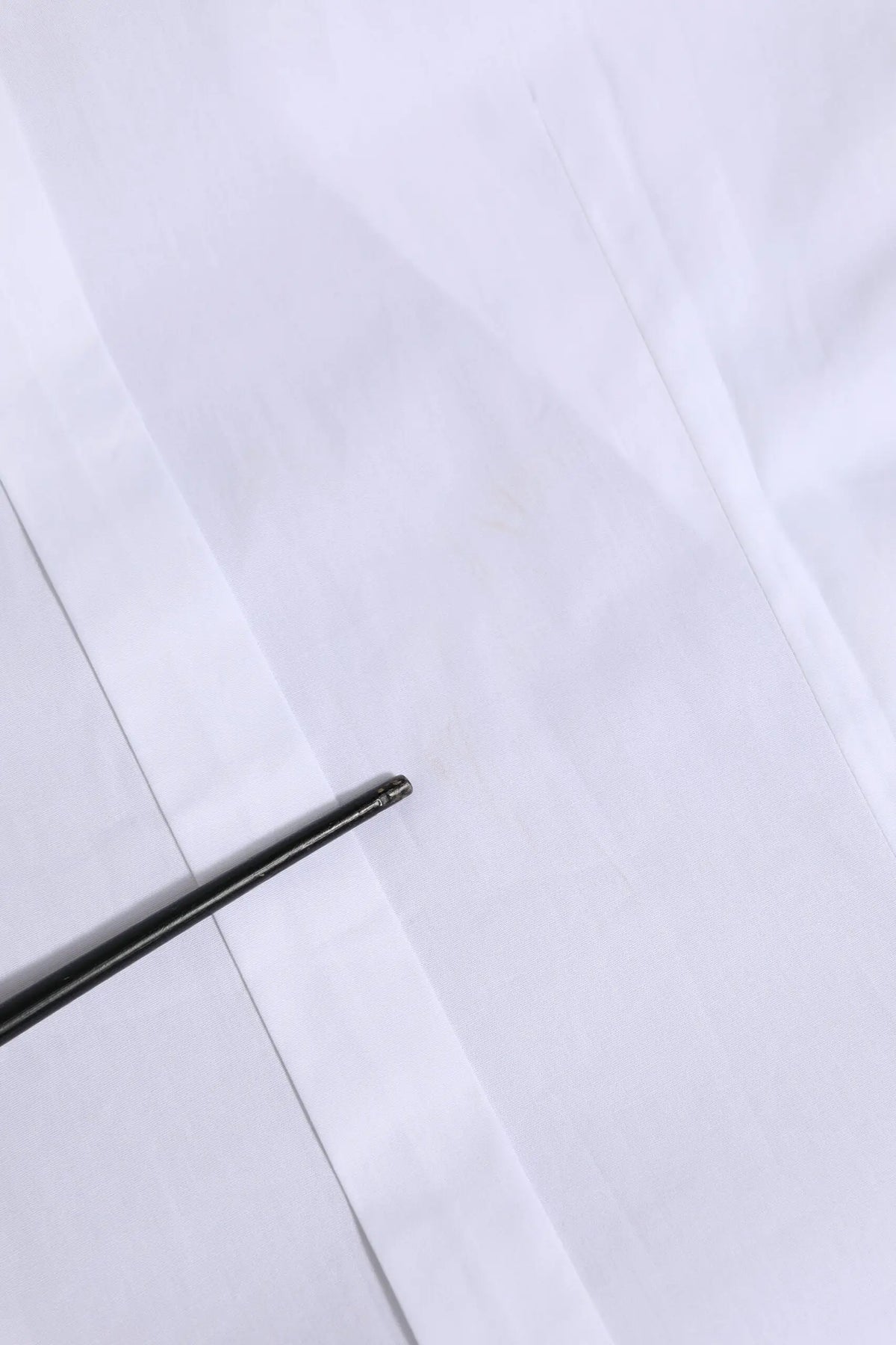 Stylo noir à pointe métallique élégante posé sur papier blanc avec chemise formelle blanche en coton à manches longues dolce & gabbana gold