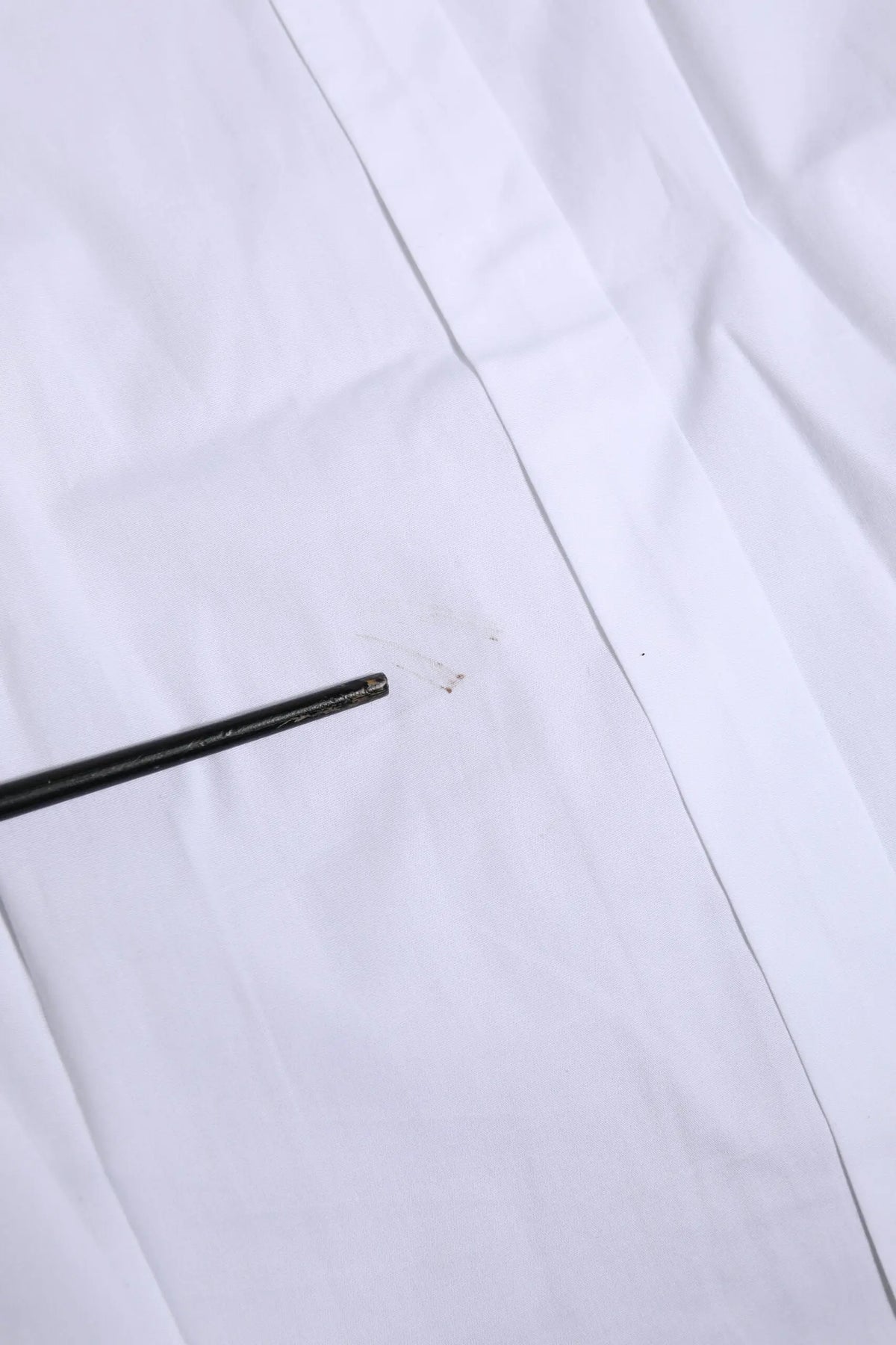 Chopstick noir reposant sur un tissu blanc du chemise formelle en coton blanc à manches longues gold de Dolce & Gabbana