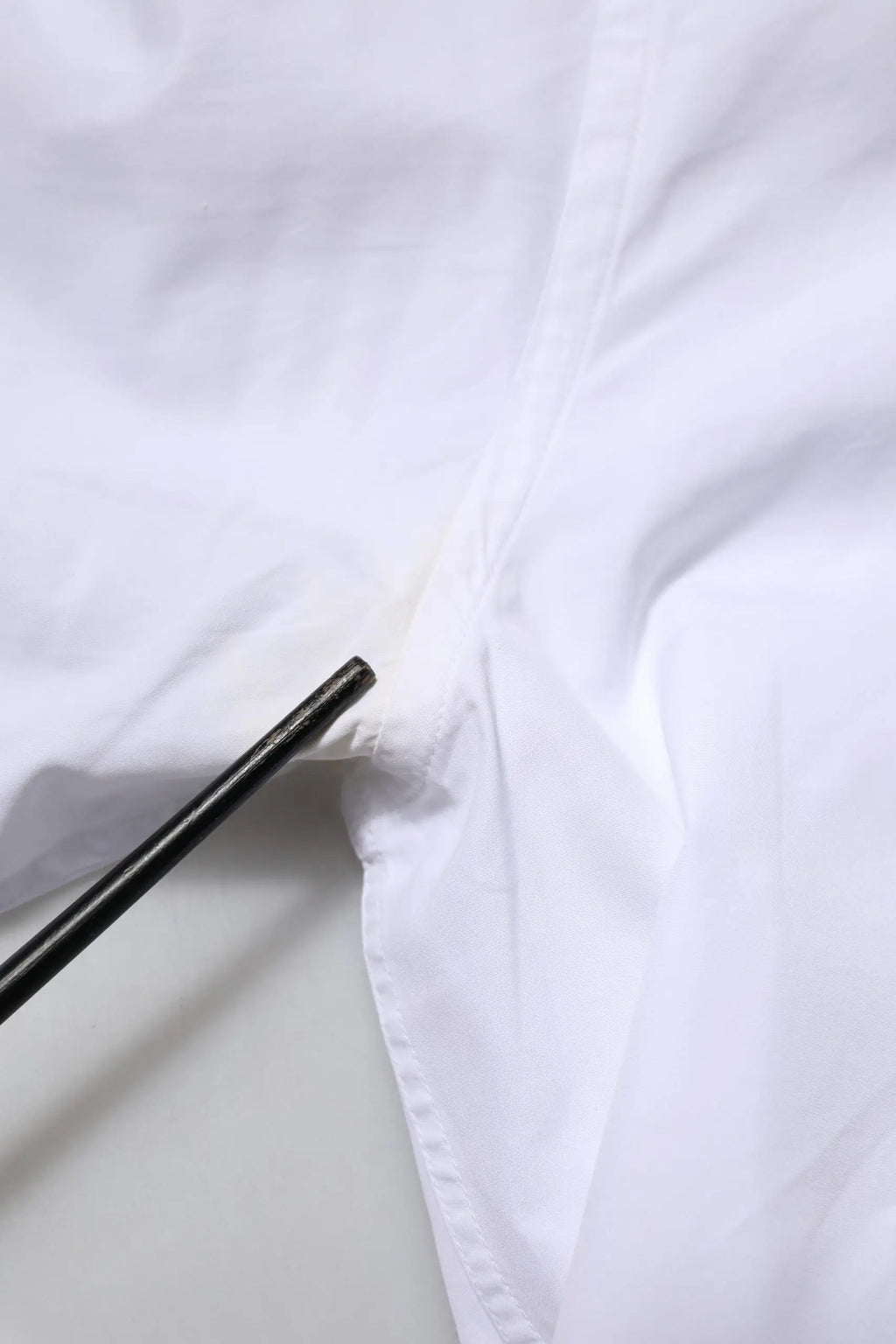Chopsticks noirs posés sur un tissu blanc en coton froissé dolce & gabbana chemise homme manches longues or